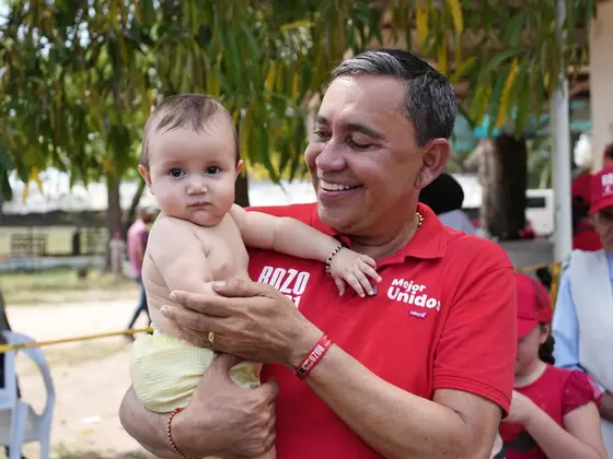 Germán Rozo carga a un bebé durante una jornada comunitaria