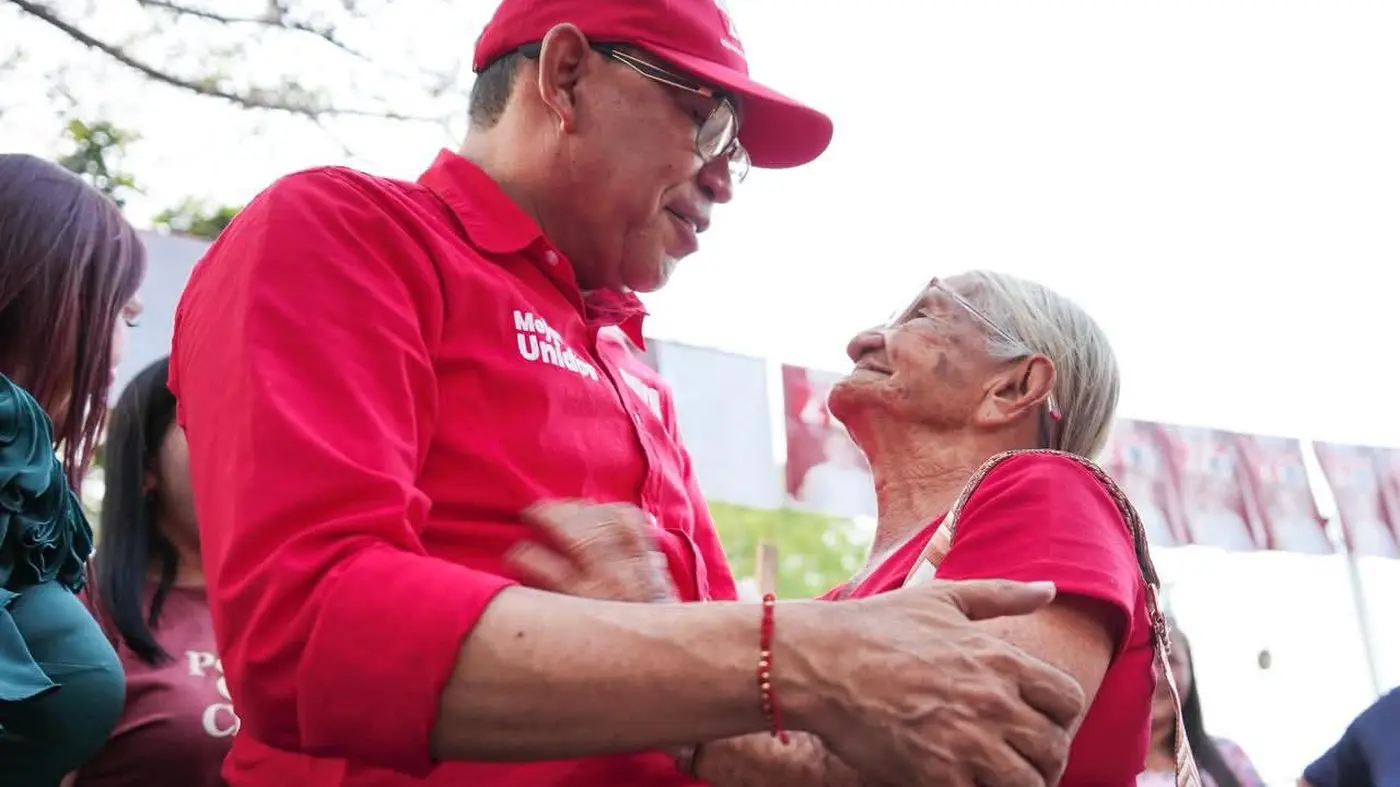 Germán Rozo abraza a una adulta mayor durante una jornada en el territorio